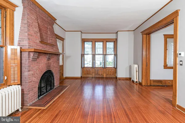 a view of a livingroom with a fireplace wooden floor and a window