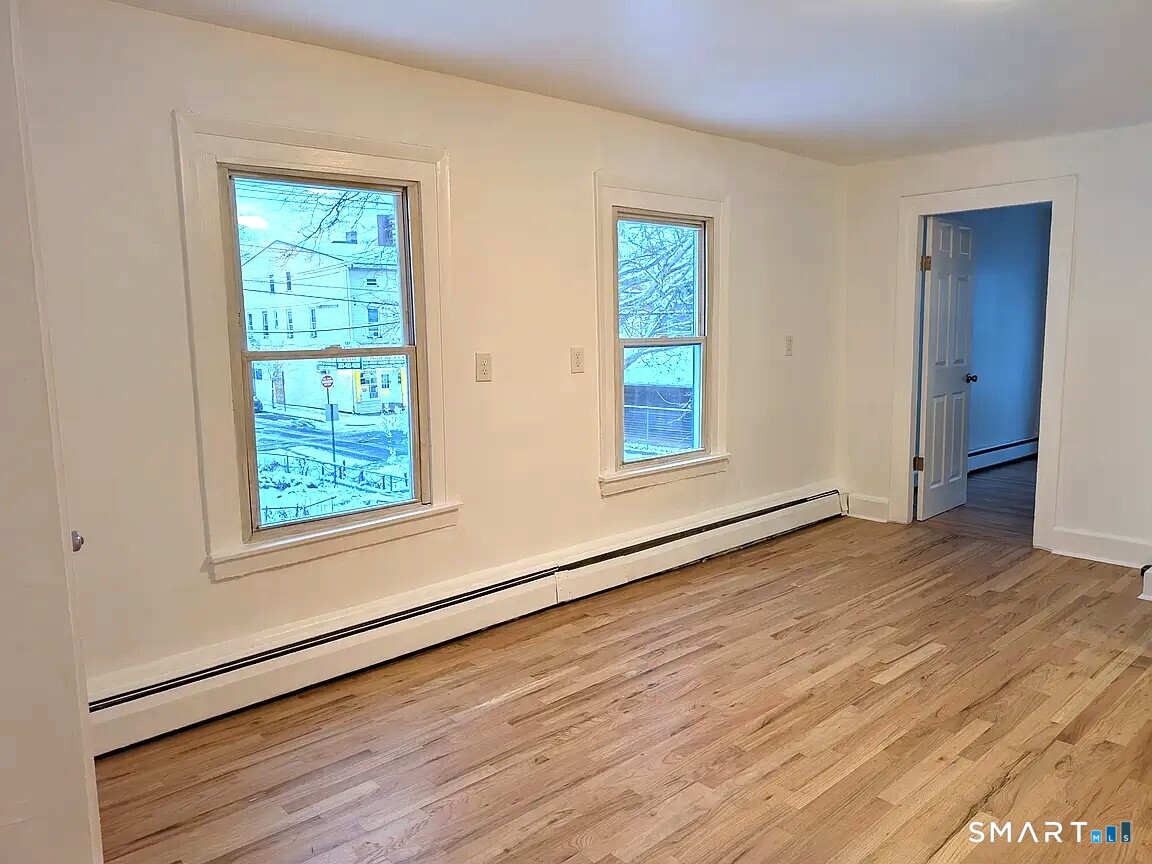 64 Liberty Street New Haven, CT 06519 - Photo 2 of 7 a view of an empty room with wooden floor and a window