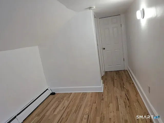 a view of a room with wooden floor and white walls