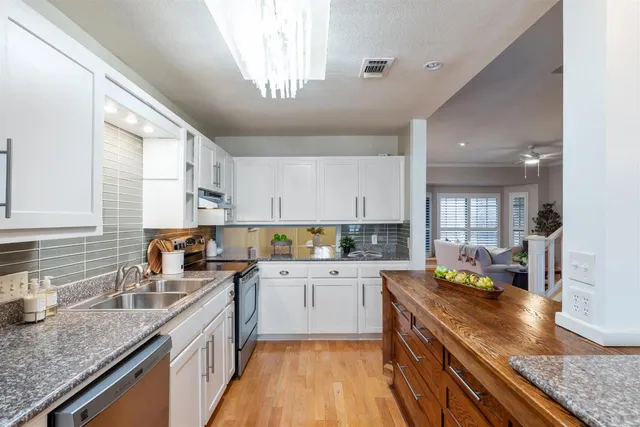a kitchen with stainless steel appliances granite countertop sink stove top oven and cabinets