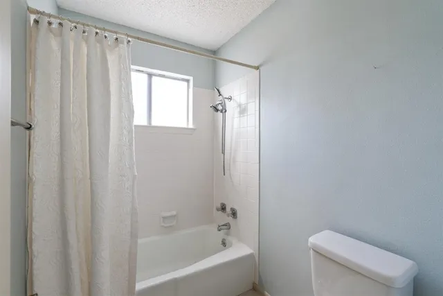 a bathroom with a shower a toilet and a sink