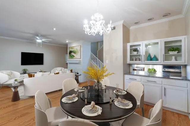 a dining room with furniture a chandelier and wooden floor