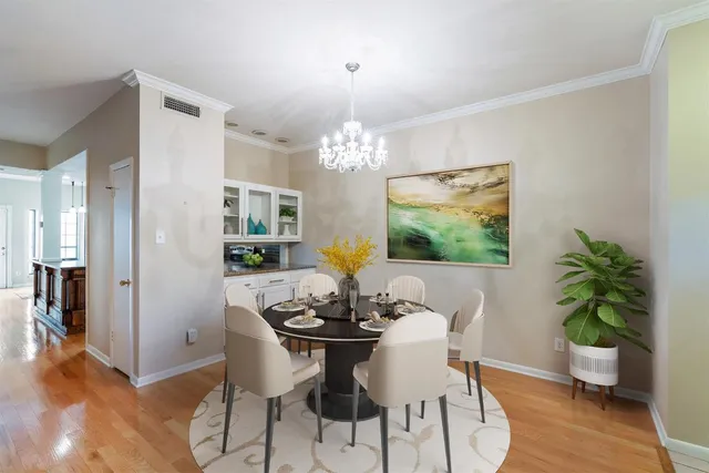 a dining room with furniture potted plants and wooden floor