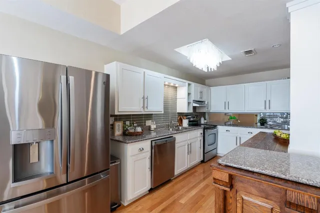 a kitchen with a refrigerator a sink a stove and cabinets