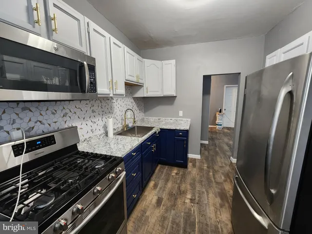 a kitchen with stainless steel appliances granite countertop a stove a refrigerator and a microwave