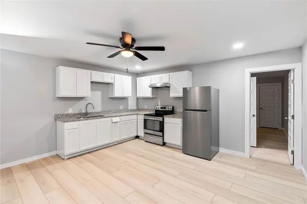 a kitchen with stainless steel appliances granite countertop a refrigerator and a stove top oven