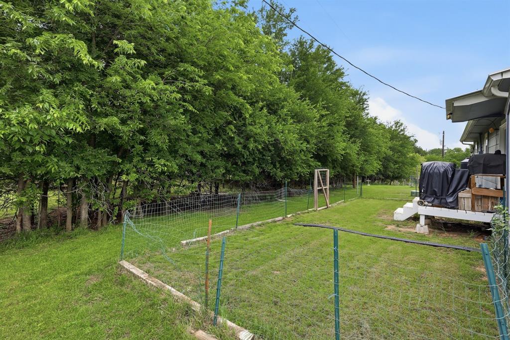 767 East Barry Street Azle, TX 76020 - Photo 19 of 40 The property features a spacious yard with mature trees and a fenced area
