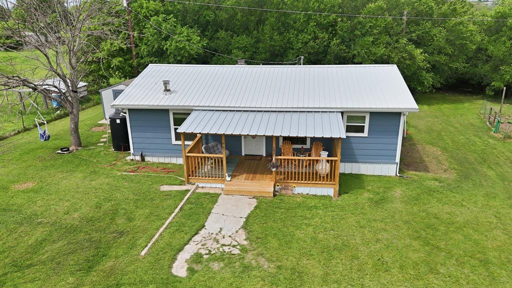 767 East Barry Street Azle, TX 76020 - Photo 2 of 40 The property features a charming exterior with blue siding and a light-colored metal roof