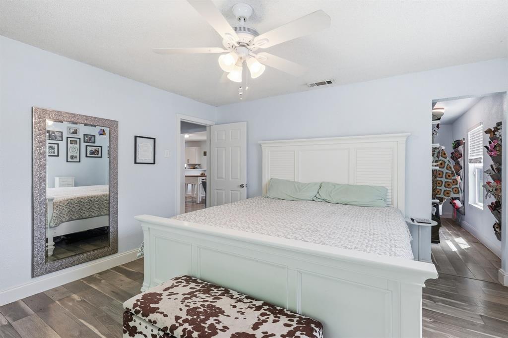 767 East Barry Street Azle, TX 76020 - Photo 22 of 40 This spacious room features light-colored walls, a ceiling fan, and wood-look flooring