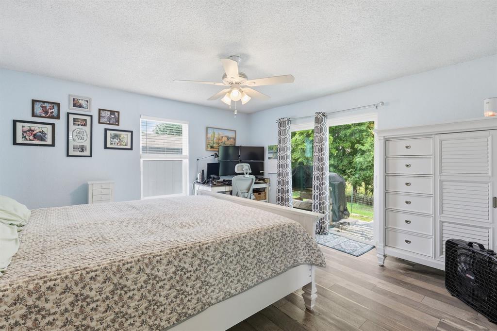 767 East Barry Street Azle, TX 76020 - Photo 23 of 40 This room features light blue walls, wood-look flooring, and a ceiling fan