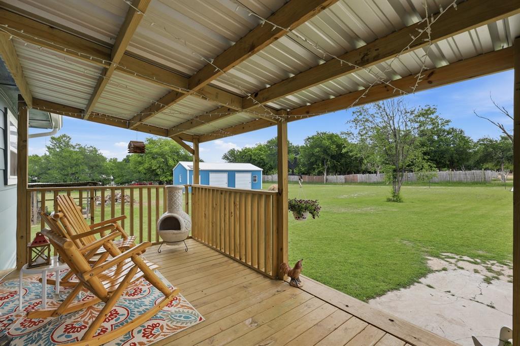 767 East Barry Street Azle, TX 76020 - Photo 3 of 40 The property features a covered wooden porch with a metal roof