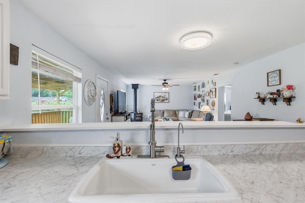 767 East Barry Street Azle, TX 76020 - Photo 31 of 40 The kitchen features a white sink with a contemporary faucet, set within a light-colored countertop
