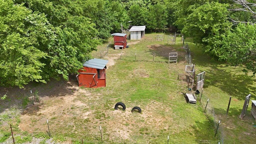 767 East Barry Street Azle, TX 76020 - Photo 6 of 40 The property includes several fenced areas, two red sheds with grey roofs, and a smaller white shed