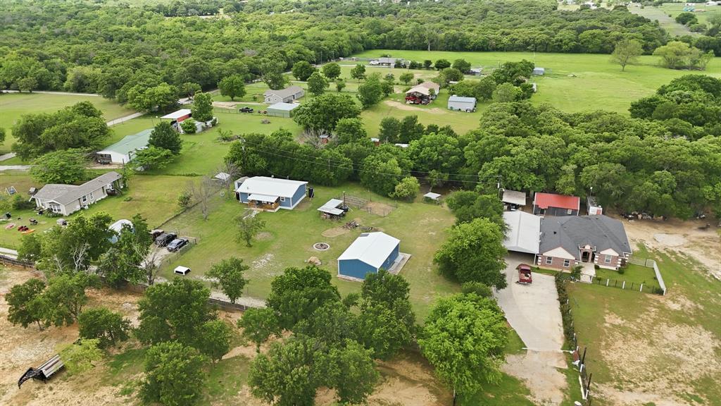 767 East Barry Street Azle, TX 76020 - Photo 10 of 40 The property features a spacious lot with mature trees, green lawns, and a private driveway