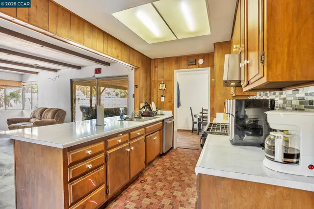 a kitchen with sink a counter top space and living room