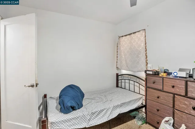 a bedroom with a bed window and dresser
