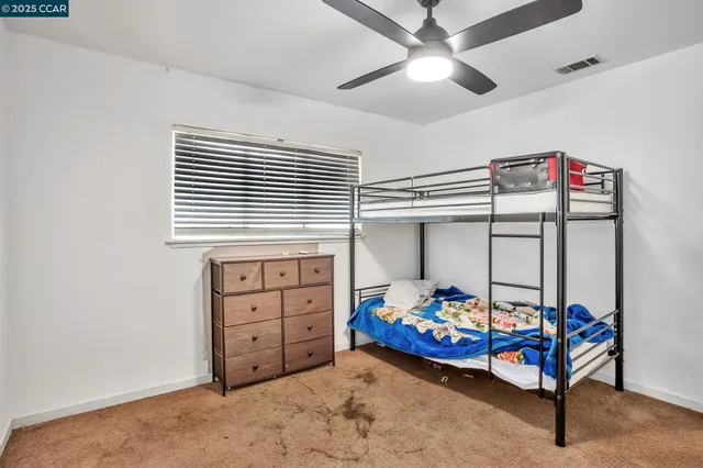 a bedroom with a bunk bed and a window
