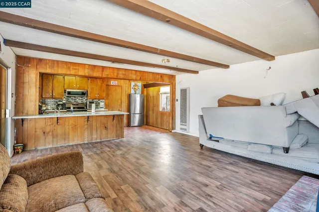 a living room with hard wood floors and a floor to ceiling window