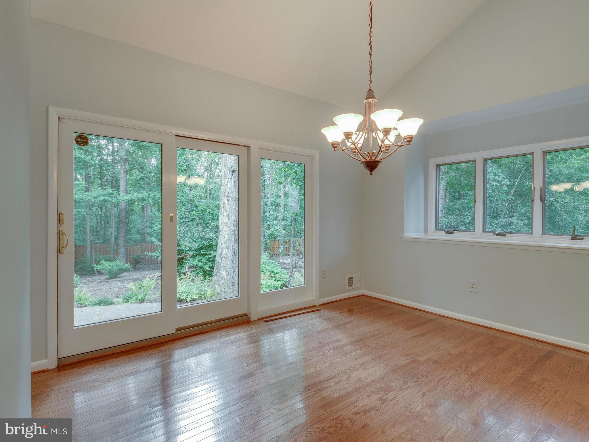 2437 Freetown Drive Reston, VA 20191 - Photo 12 of 30 a view of a chandelier in big room with wooden floor and a chandelier