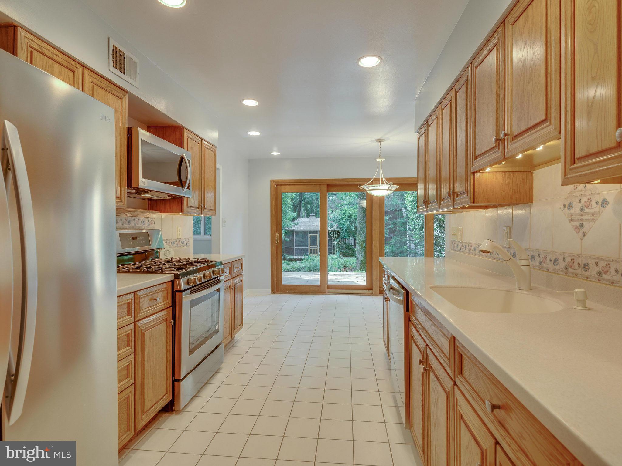 2437 Freetown Drive Reston, VA 20191 - Photo 16 of 30 a kitchen with stainless steel appliances granite countertop a sink stove and refrigerator