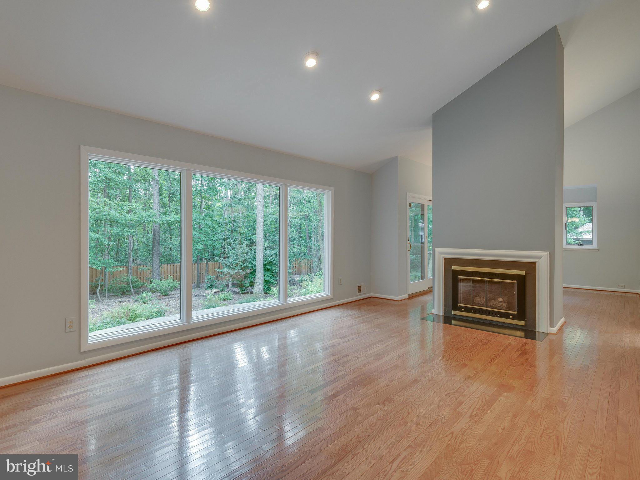 2437 Freetown Drive Reston, VA 20191 - Photo 9 of 30 a view of an empty room with wooden floor fireplace and a window