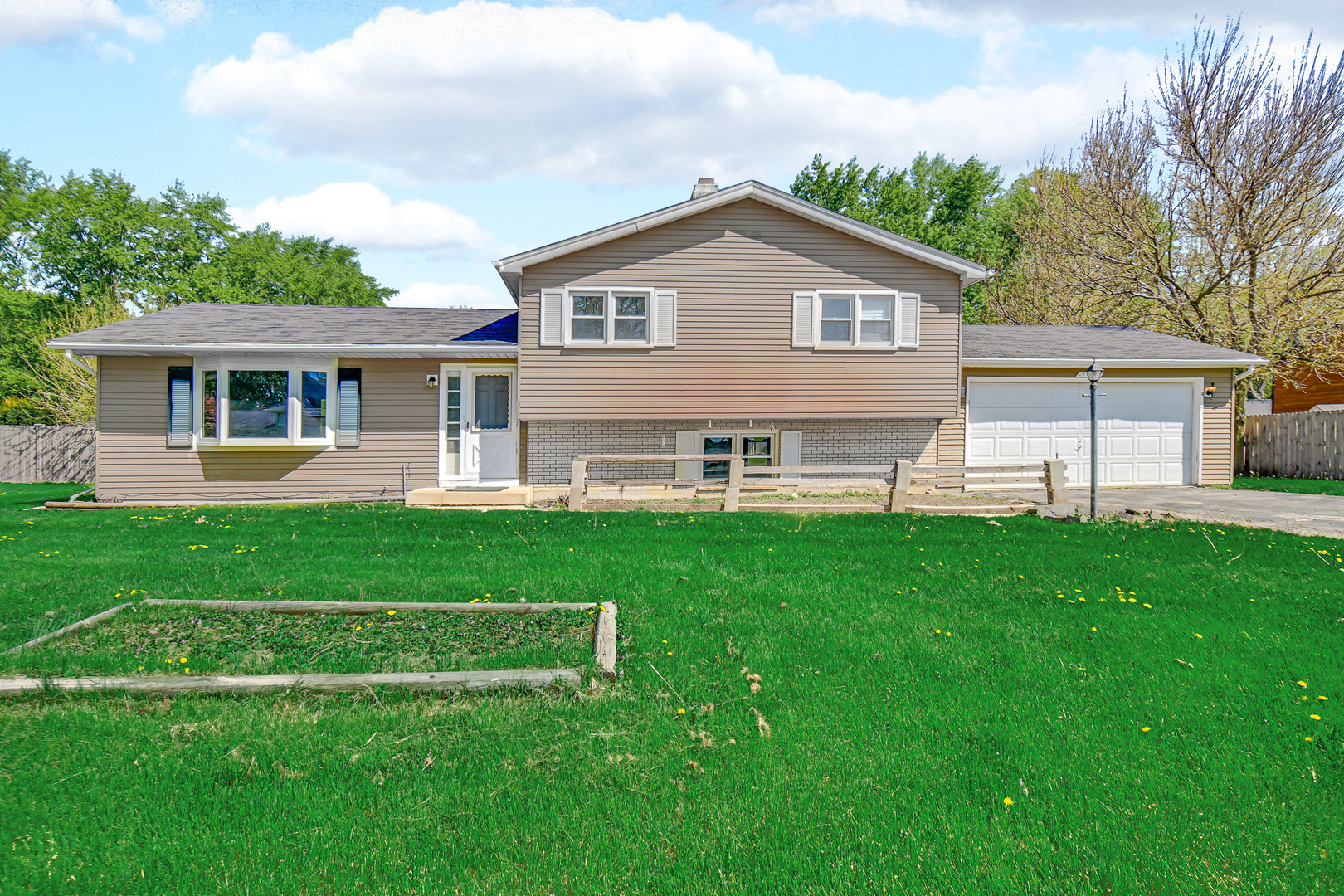 a front view of a house with a yard and green space