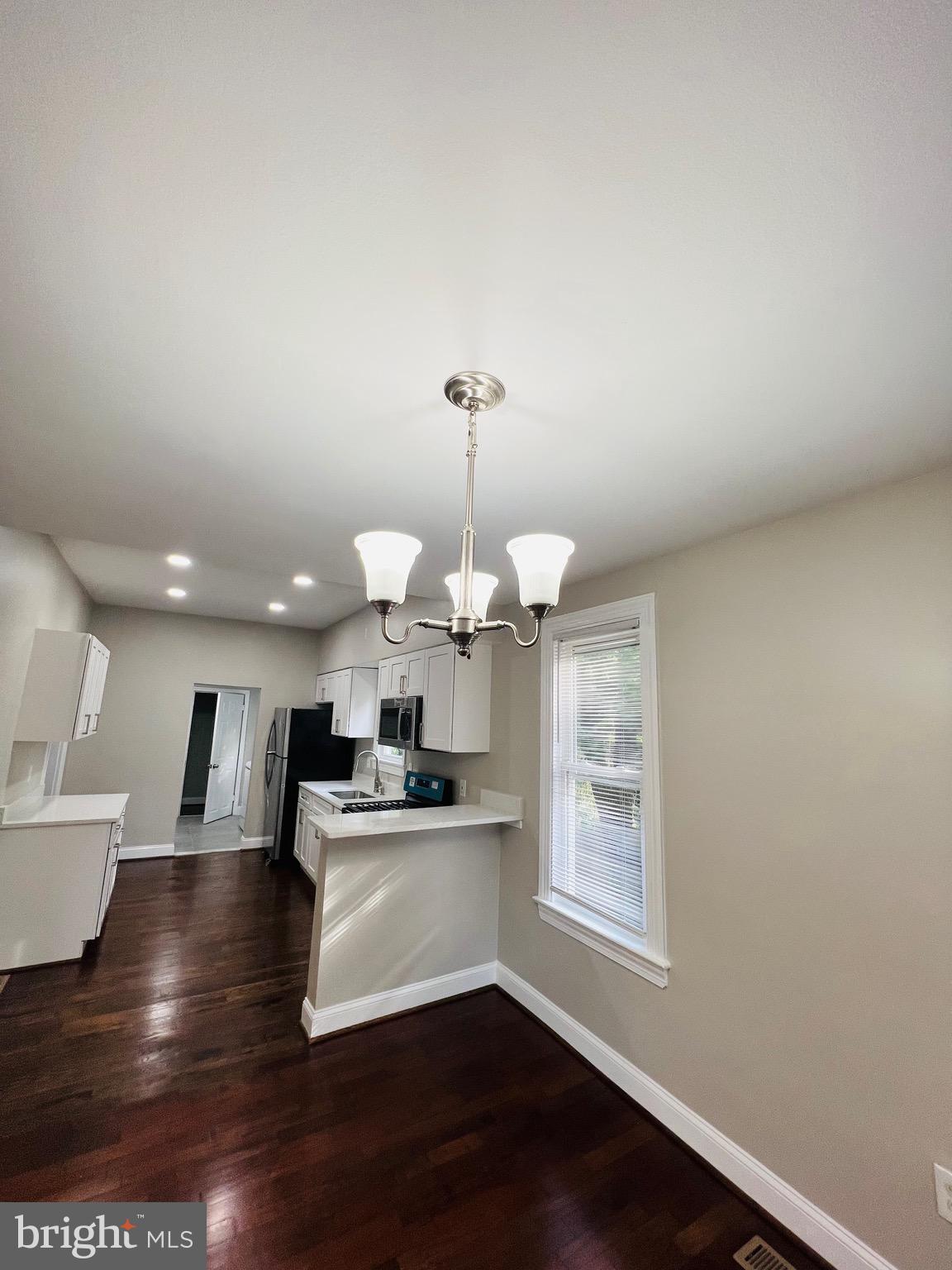 5709 Dade Street Capitol Heights, MD 20743 - Photo 13 of 23 a view of a kitchen with a sink wooden floor and a living room