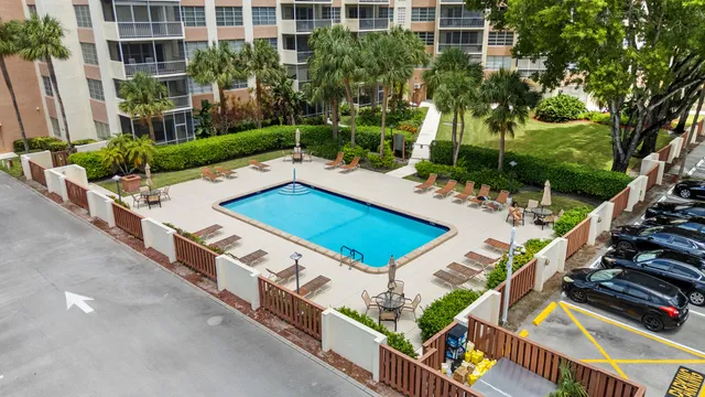an aerial view of a house with pool and trees