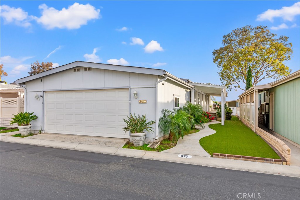 a view of a house with a yard and potted plants