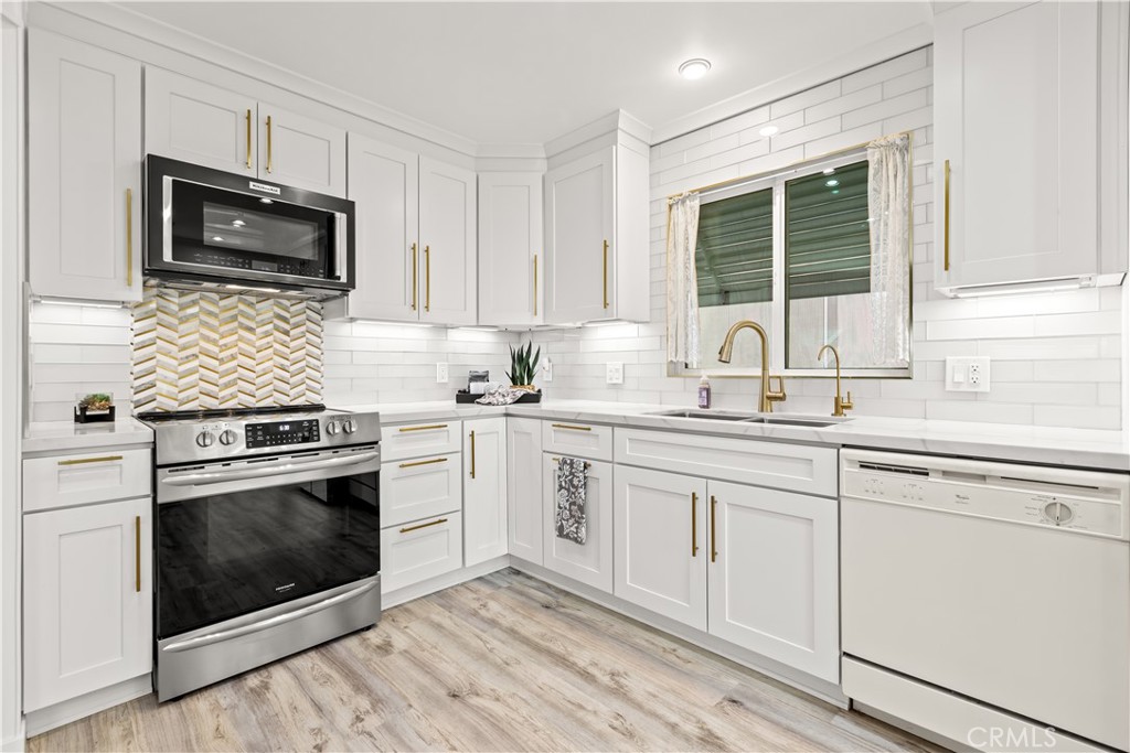 5200 Irvine Boulevard Irvine, CA 92620 - Photo 8 of 52 a kitchen with granite countertop white cabinets stainless steel appliances and sink