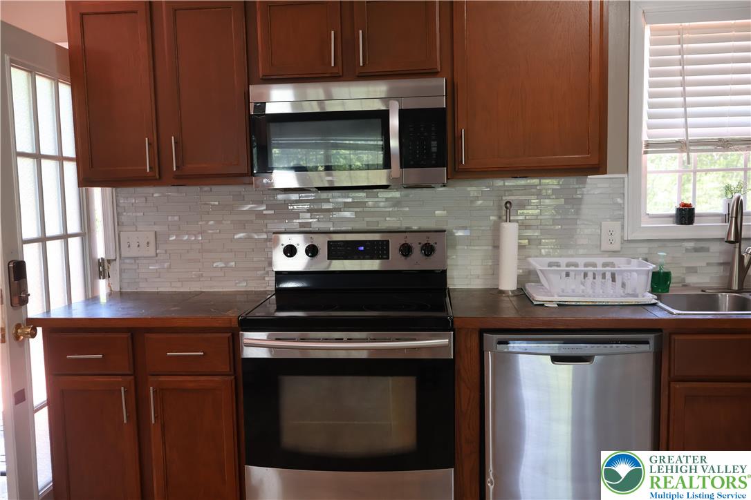1646 Clover Road Long Pond, PA 18334 - Photo 3 of 20 a kitchen with stainless steel appliances a stove a microwave sink and cabinets