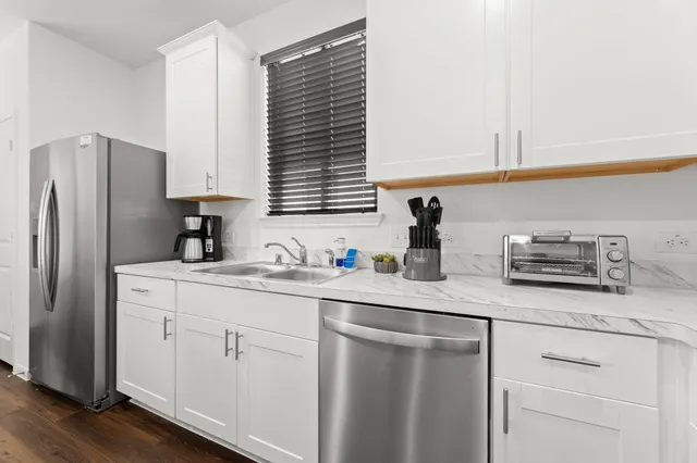 a kitchen with stainless steel appliances white cabinets and a refrigerator