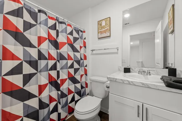 a bathroom with a sink a toilet and shower curtain