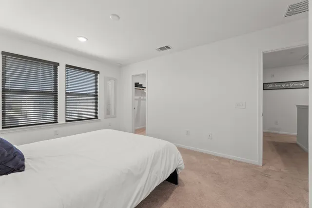 a bedroom with a bed and a large window