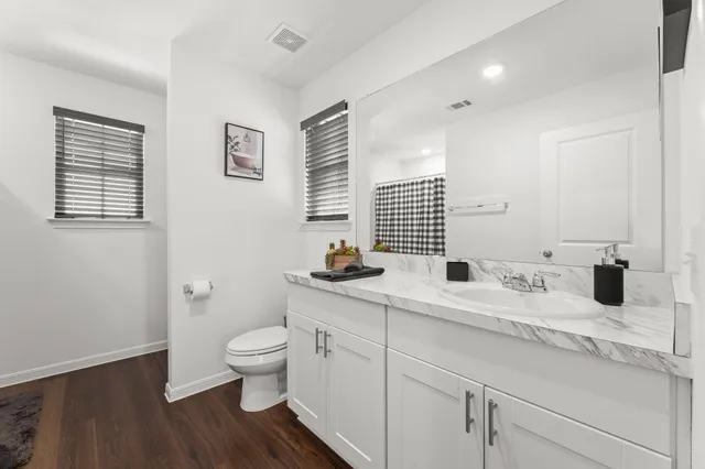a bathroom with a double vanity sink toilet and a mirror