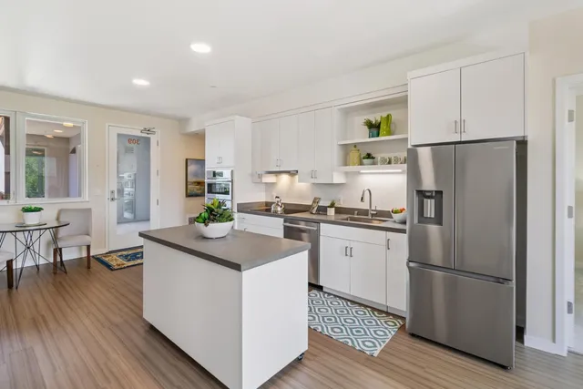 a kitchen with a refrigerator a sink and cabinets
