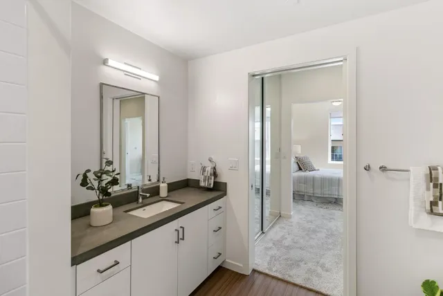a en suite bathroom with a sink and mirror with toilet