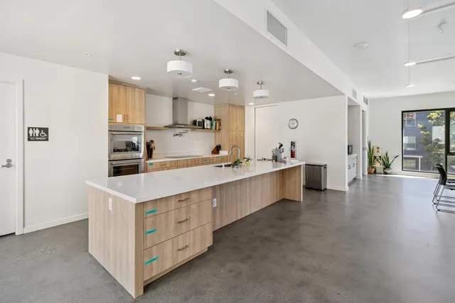 a open kitchen with kitchen island a sink stainless steel appliances and white cabinets