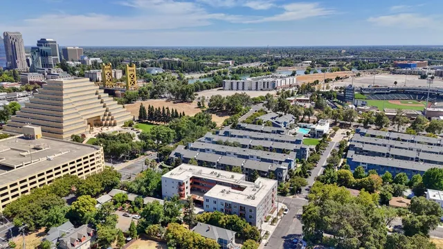 an aerial view of a city with lots of residential buildings ocean and mountain view in back