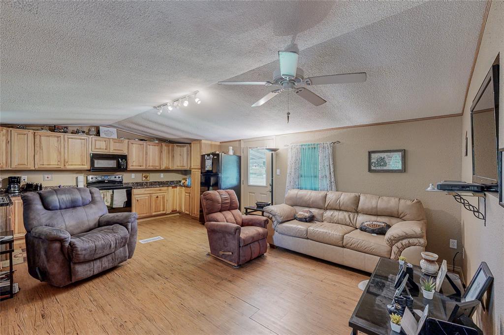 1501 Joyce Road Kaufman, TX 75142 - Photo 21 of 37 a living room with furniture kitchen view and a wooden floor