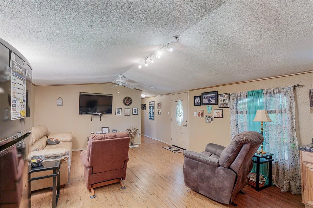 1501 Joyce Road Kaufman, TX 75142 - Photo 27 of 37 a living room with furniture and a flat screen tv