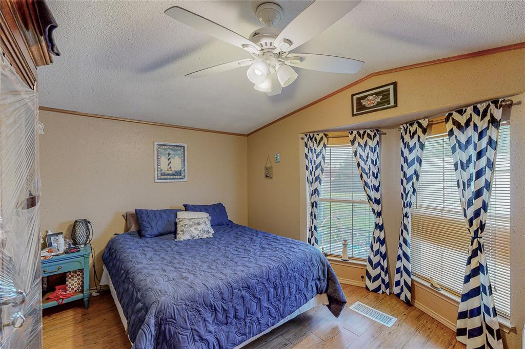 1501 Joyce Road Kaufman, TX 75142 - Photo 28 of 37 a bedroom with a bed and a chandelier