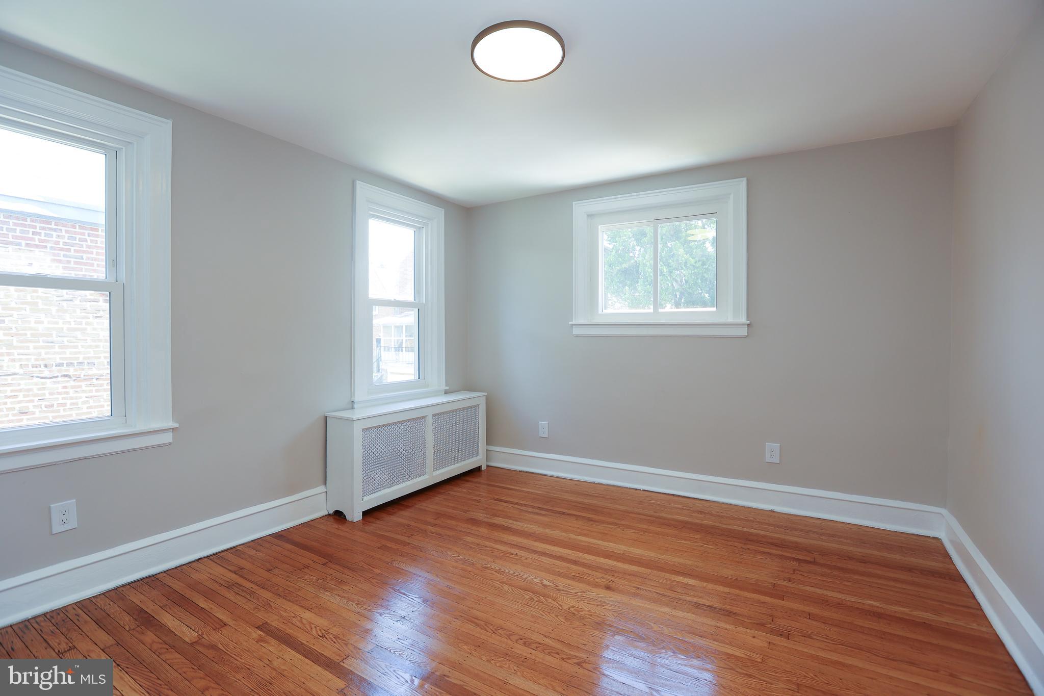12 East Providence Road Lansdowne, PA 19050 - Photo 18 of 30 an empty room with wooden floor and windows
