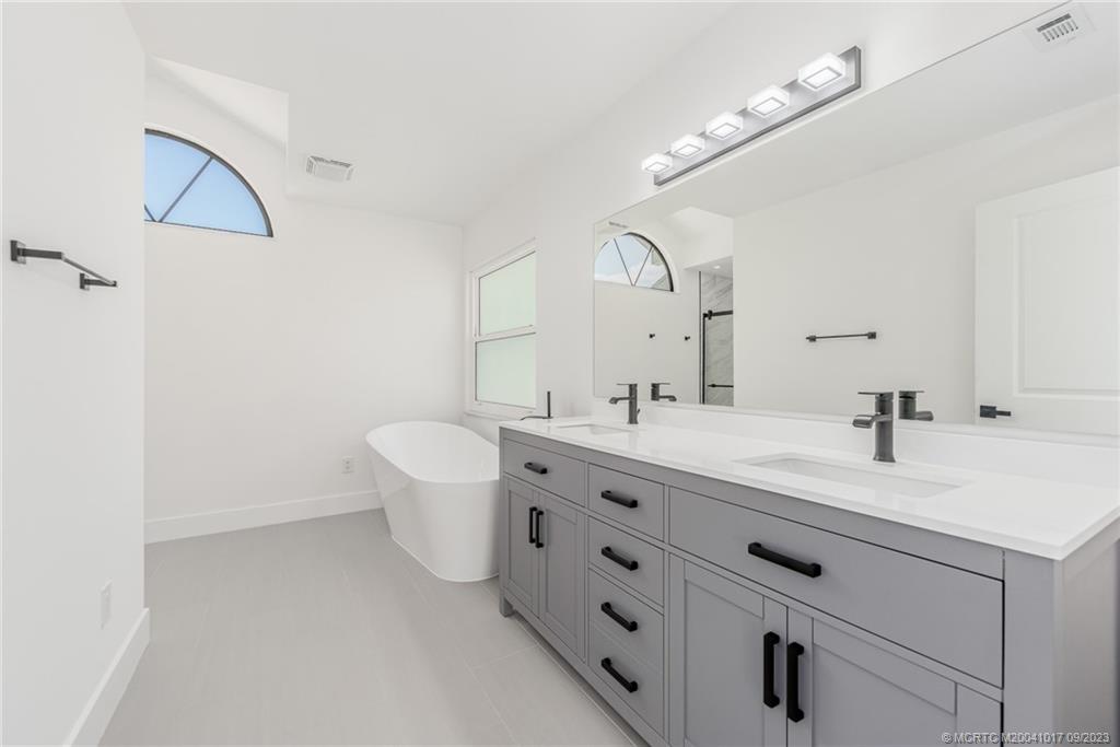 5008 Southeast Major Way Stuart, FL 34997 - Photo 12 of 20 a bathroom with a double vanity sink mirror and toilet