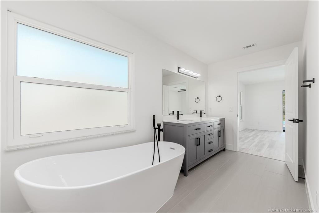 5008 Southeast Major Way Stuart, FL 34997 - Photo 13 of 20 a spacious bathroom with a tub sink and mirror