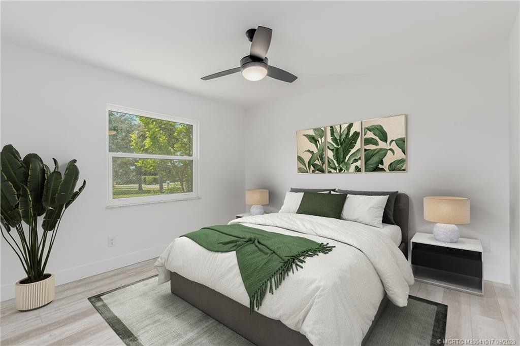 5008 Southeast Major Way Stuart, FL 34997 - Photo 17 of 20 a bedroom with a bed and a potted plant