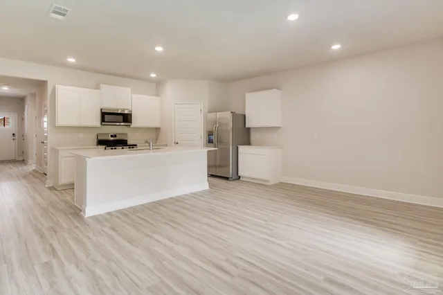 a kitchen with stainless steel appliances a refrigerator sink and microwave