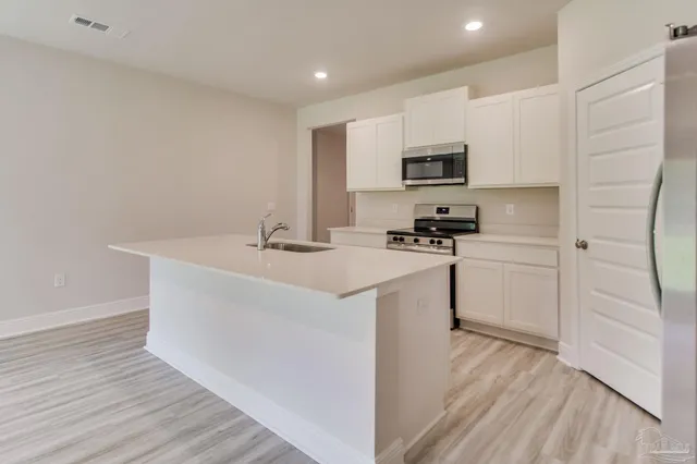 a kitchen with a sink a microwave a stove and refrigerator