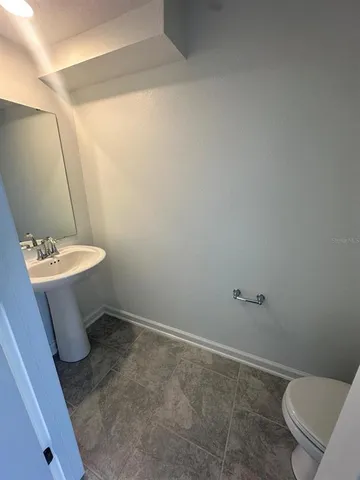 a bathroom with a toilet a sink and a mirror