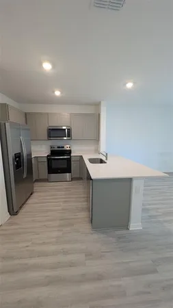 a large white kitchen with stainless steel appliances